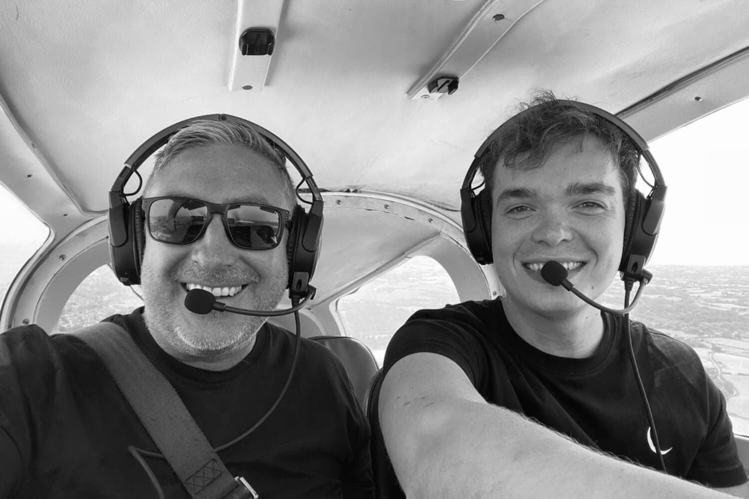 Two pilots wearing headsets in an aircraft cockpit